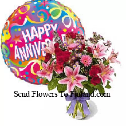 Flores variadas en un jarrón junto con un globo de aniversario